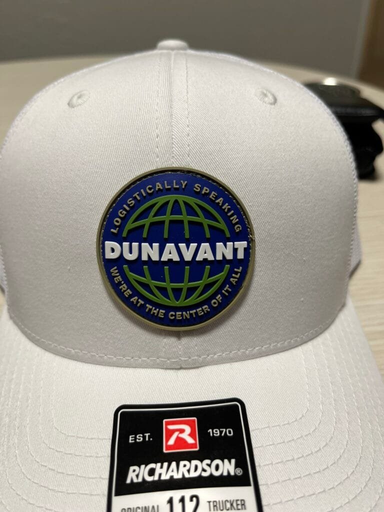 White cap with a circular Dunavant logo patch on the front and a Richardson tag below the badge.