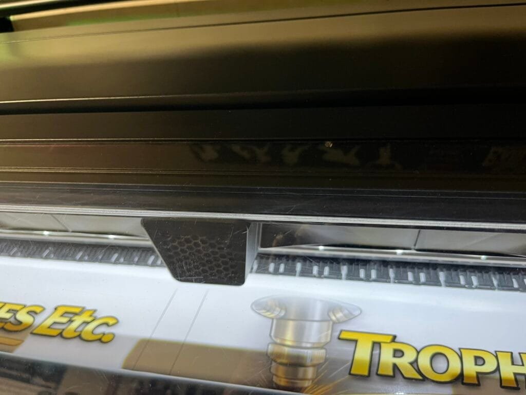 HP Latex large-format printer producing a full-color custom sign for Trophies Etc.