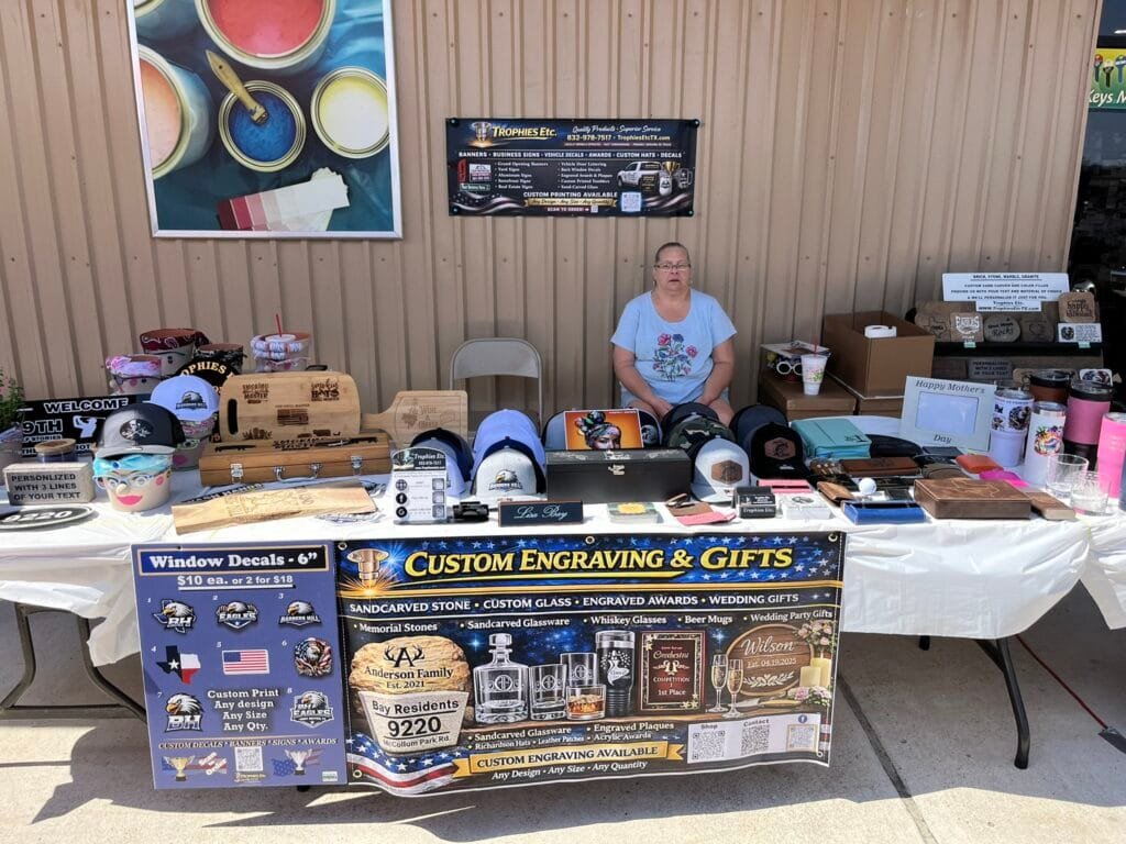 Trophies Etc. custom engraving and personalized gifts display at a local vendor event in Baytown, TX.