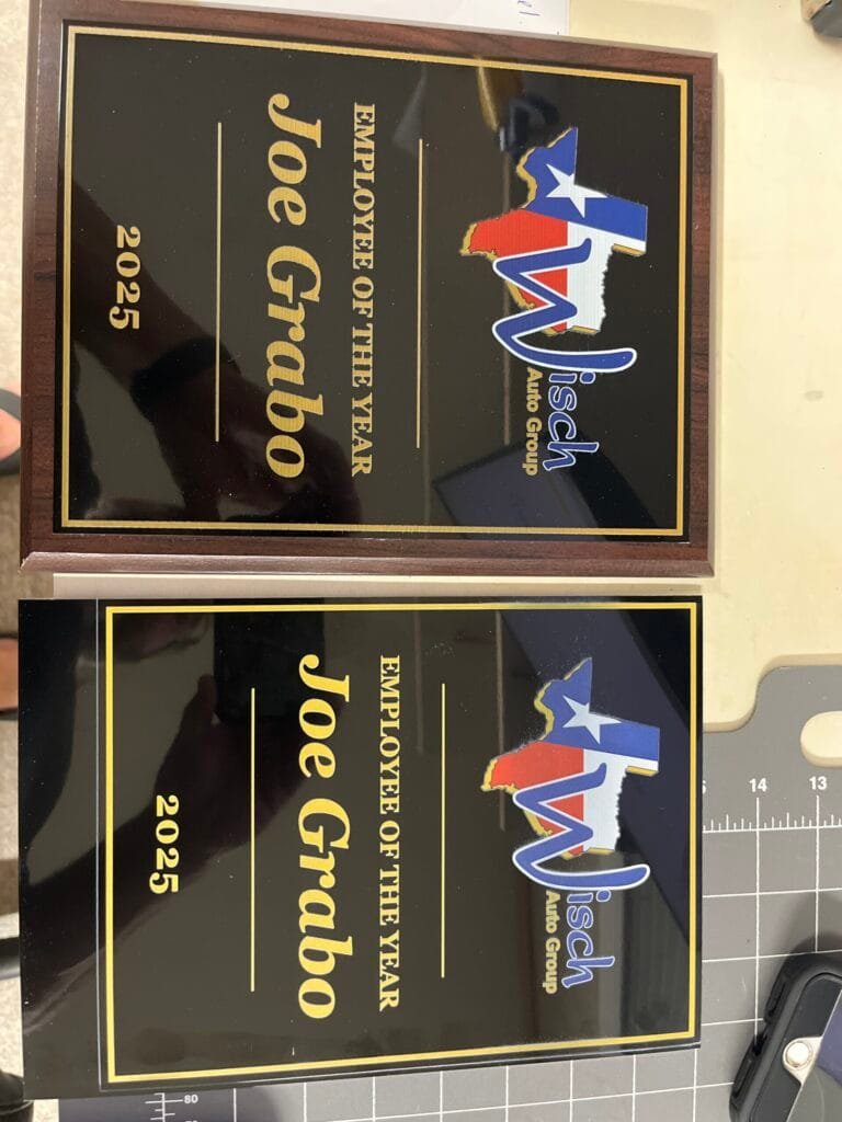 Award plaque reading'Employee of the Year 2025' with the name 'Joe Grabo' and a Texas-shaped logo from an auto group.